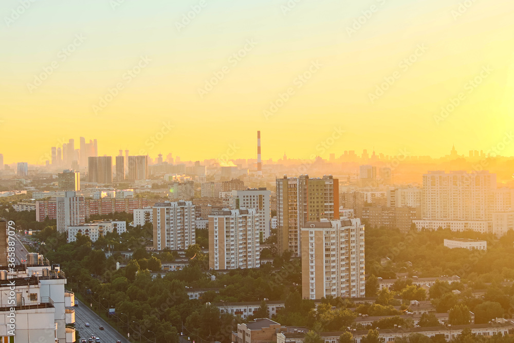 Cityscape of Moscow city in Russia during golden sunset. Small haze in the air. Blurred Moscow International Business Center in the background. Golden hour theme.