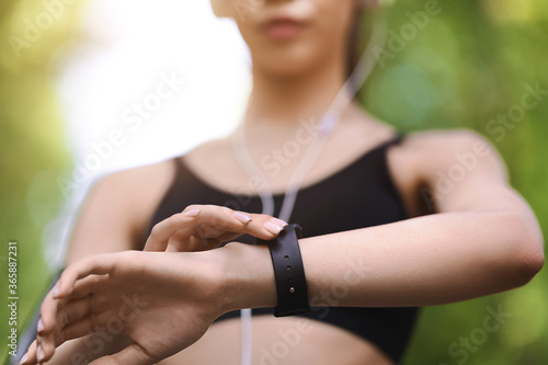 Gadgets For Sport. Female athlete using smartwatch outdoors to track training progress