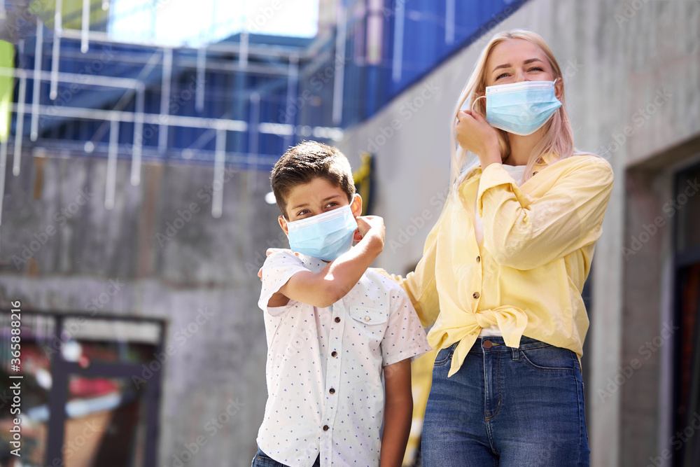 mother and child in medical masks in streets, they walk outdoors after quarantine ending. coronavirus outbreak mother and child in medical masks in streets, they walk outdoors after quarantine ending. coronavirus outbreak
