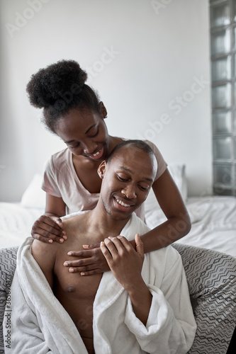 gentle, sensitive black afroamerican couple at home, young lady treats her husband with love, couple in chime