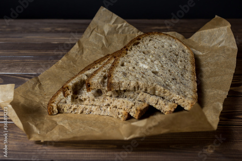 Freshly baked slice of bread sliced ​​on wrapping paper.