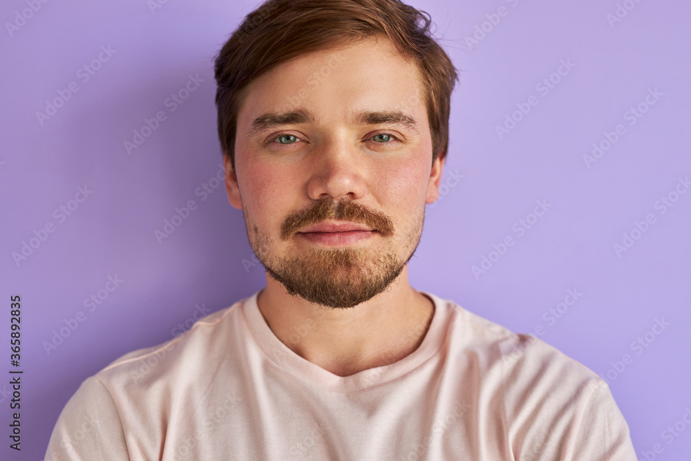 Obraz premium portrait of mysterious caucasian man isolated over purple background, handsome calm guy is in contemplation