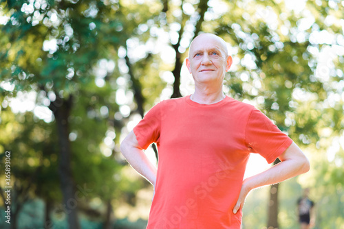 Happy thoughtful senior man standing in the park. High quality photo