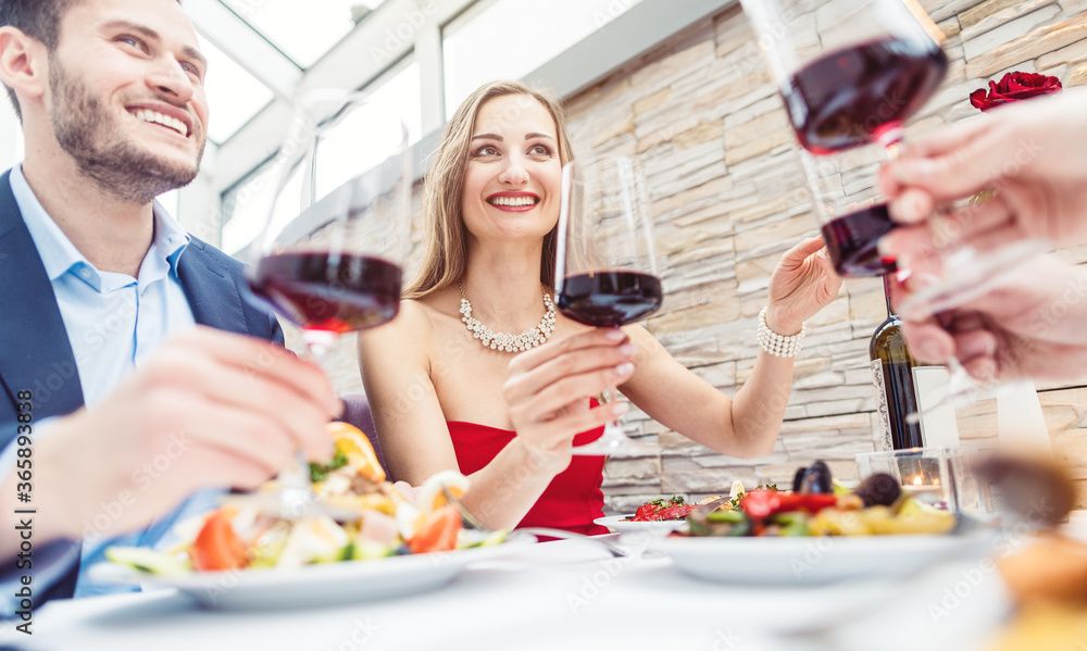 Friends in a fancy restaurant toasting with Italian red wine Friends in a fancy restaurant toasting with Italian red wine