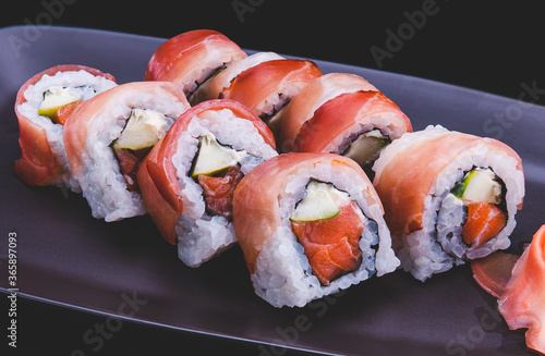 Japanese sushi roll with raw ham slice cut. photo