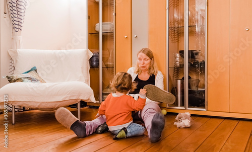 Mature woman with toddler sitting on floor