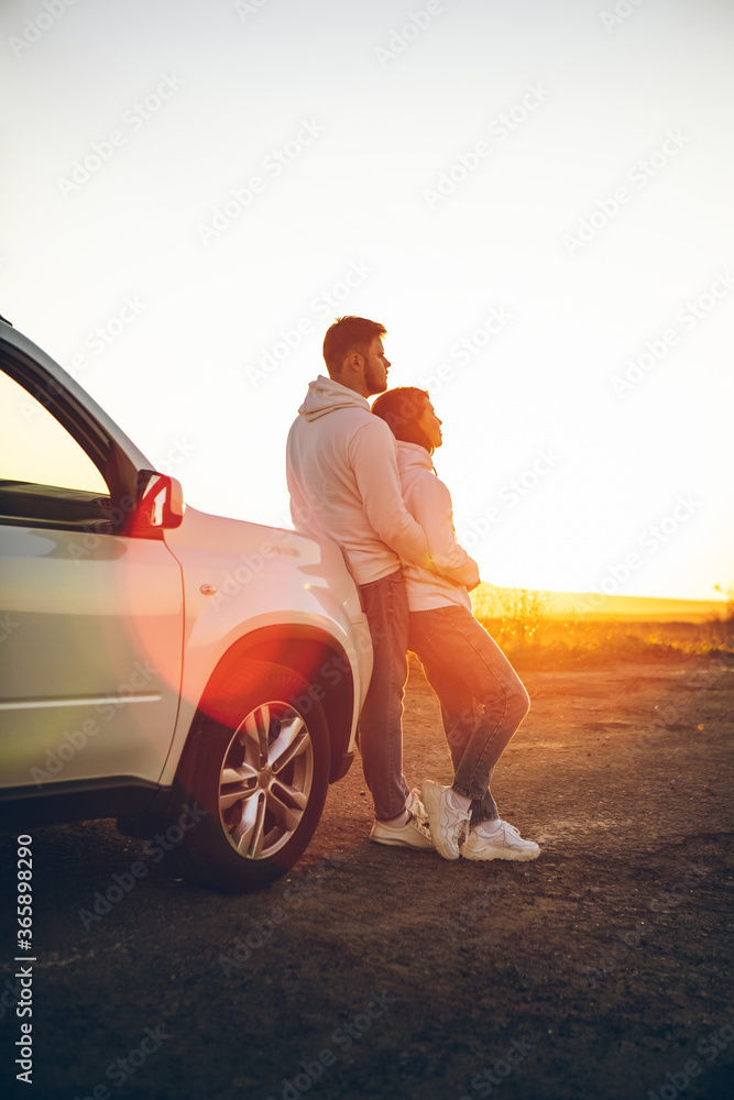 romantic moment couple looking on sunset near white suv car romantic moment couple looking on sunset near white suv car