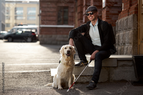 the concept of the young blind invalid and the dog guide, little golden retriever help man to cross streets