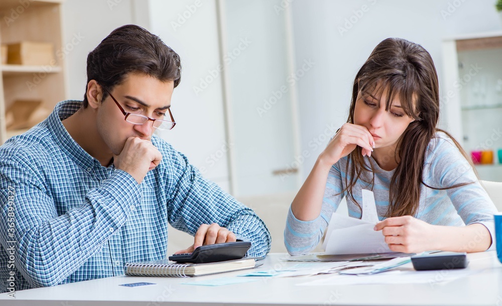 Young couple looking at family finance papers Young couple looking at family finance papers