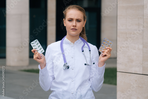 The young doctor's girlfriend is holding pills in her hands. photo