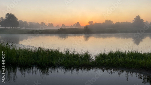 sunrise foggy morning on the golf course pond reflections