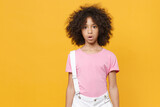Shocked little african american kid girl 12-13 years old in pink t-shirt isolated on yellow background children studio portrait. Childhood lifestyle concept. Mock up copy space. Keeping mouth open.