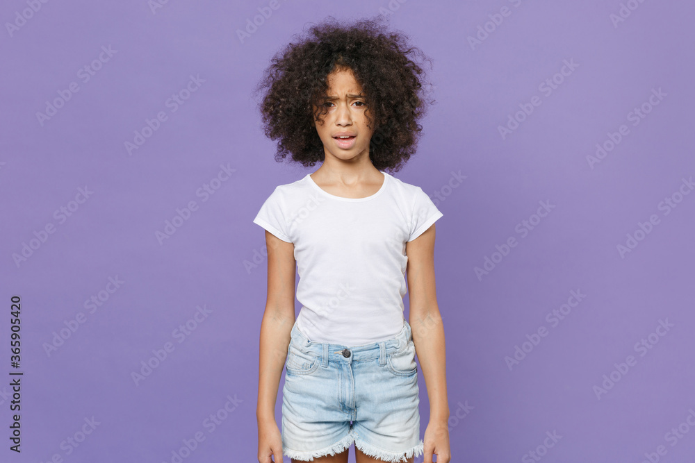 Shocked worried little african american kid girl 12-13 years old in white t-shirt isolated on violet background studio portrait. Childhood lifestyle concept. Mock up copy space. Keeping mouth open. Shocked worried little african american kid girl 12-13 years old in white t-shirt isolated on violet background studio portrait. Childhood lifestyle concept. Mock up copy space. Keeping mouth open.