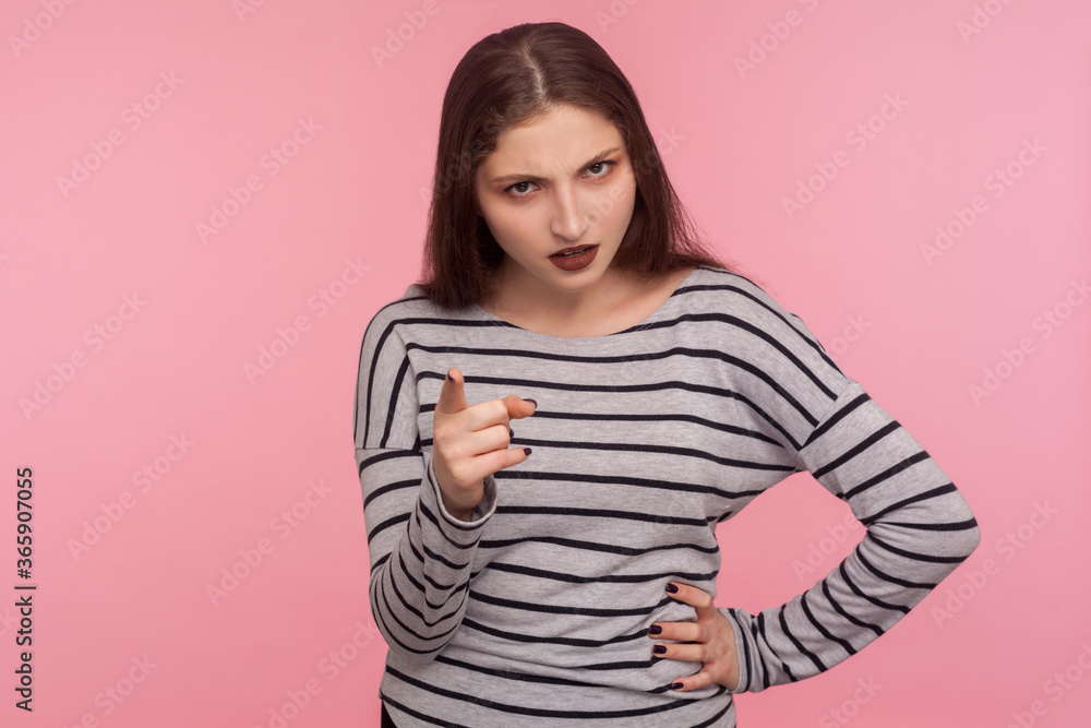 Fototapeta premium Be careful, I'm warning! Portrait of strict bossy brunette woman in striped sweatshirt giving advice, scolding with negative admonishing gesture. indoor studio shot isolated on pink background