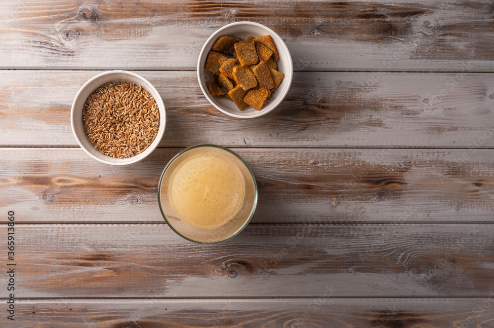 Top view homemade tradishional russian light rye kvass in glass and crackers on wooden background. Wonderful healthy refreshing drink for summer Top view homemade tradishional russian light rye kvass in glass and crackers on wooden background. Wonderful healthy refreshing drink for summer