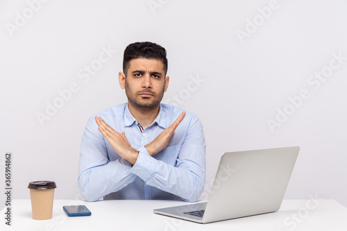 This is the end, finish! Strict boss sitting office workplace with laptop on desk, crossing hands showing x sign stop gesture, warning of troubles. indoor studio shot isolated on white background