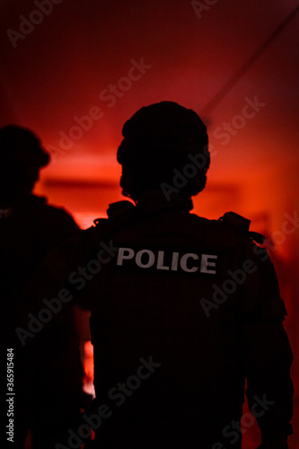 Silhouette of a police officer. Police commando in action, arresting the perpetrator in the building © edojob