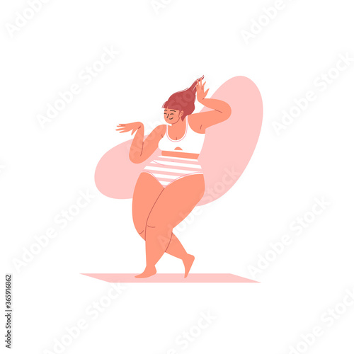 A fat woman with long hair smiling and dancing wearing a white bra and striped panties. Body positive woman dancing in underwear