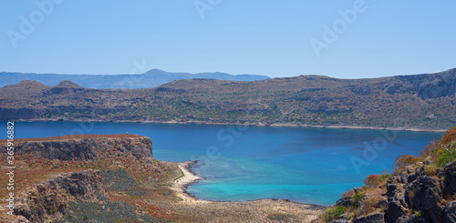 Blue lagoon and tropical sea coast with sandy beach among islands on sunny day with clear blue sky in Crete, Greece.
