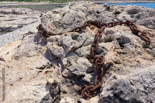 Rusted iron chain on stones.
