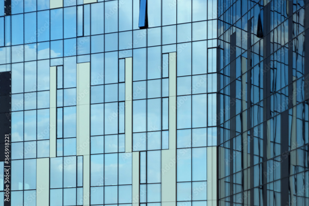 Glass office building, view of the sky reflected in the windows. Concept for work, business, offices. Copy space. Glass office building, view of the sky reflected in the windows. Concept for work, business, offices. Copy space.