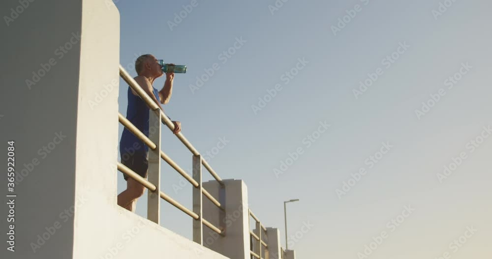 Senior man drinking water on the promenade Senior man drinking water on the promenade