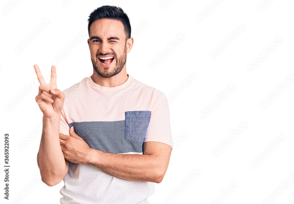 Young handsome man wearing casual clothes smiling with happy face winking at the camera doing victory sign. number two. Young handsome man wearing casual clothes smiling with happy face winking at the camera doing victory sign. number two.