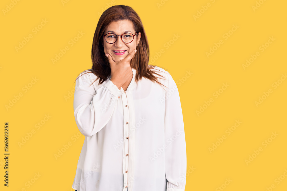 Middle age latin woman wearing casual clothes and glasses looking confident at the camera smiling with crossed arms and hand raised on chin. thinking positive.