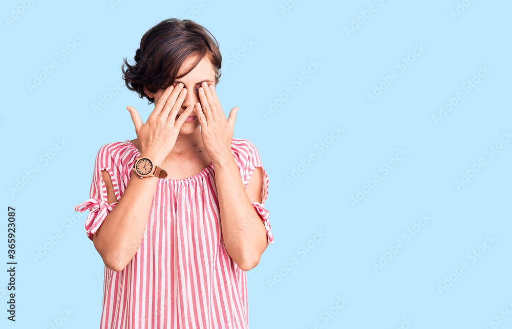 Beautiful young woman with short hair wearing casual summer clothes rubbing eyes for fatigue and headache, sleepy and tired expression. vision problem Beautiful young woman with short hair wearing casual summer clothes rubbing eyes for fatigue and headache, sleepy and tired expression. vision problem