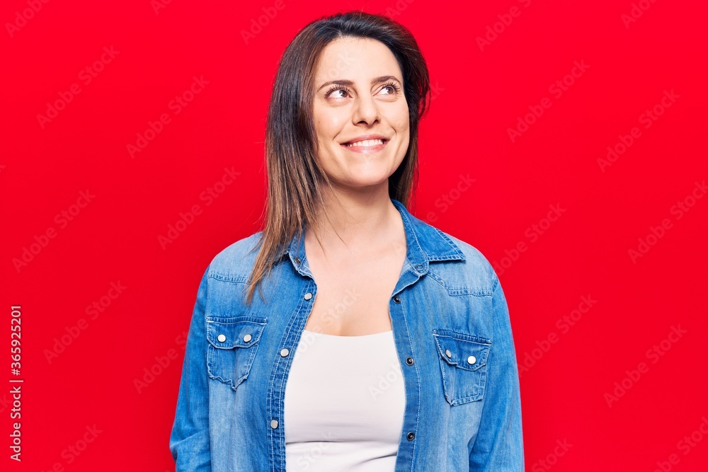 Young beautiful woman wearing casual clothes looking away to side with smile on face, natural expression. laughing confident. Young beautiful woman wearing casual clothes looking away to side with smile on face, natural expression. laughing confident.