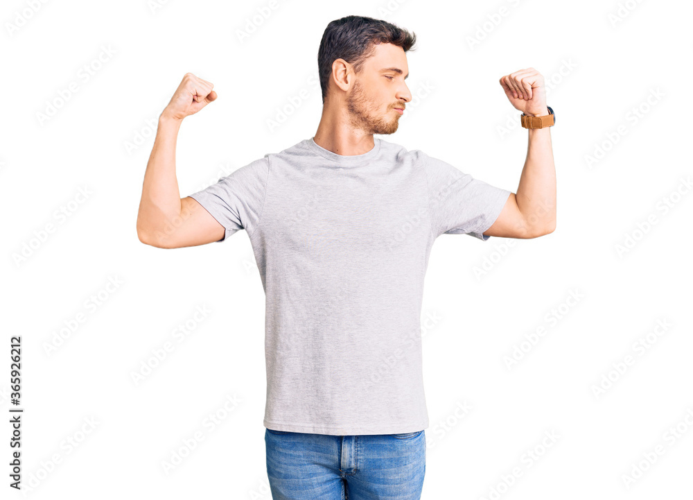 Handsome young man with bear wearing casual tshirt showing arms muscles smiling proud. fitness concept. Handsome young man with bear wearing casual tshirt showing arms muscles smiling proud. fitness concept.
