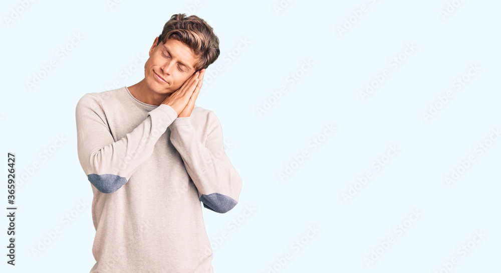 Young handsome man wearing casual clothes sleeping tired dreaming and posing with hands together while smiling with closed eyes. Young handsome man wearing casual clothes sleeping tired dreaming and posing with hands together while smiling with closed eyes.