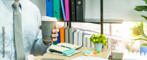 Professional Business man hand hold drink fresh coffee in paper cup glasses morning refreshing coffee break before working meeting computer smartphone mobile © Chan2545