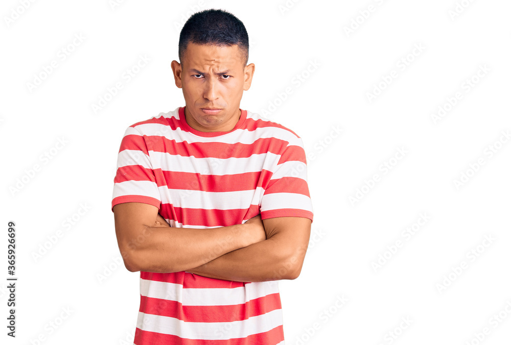 Young handsome latin man wearing casual clothes skeptic and nervous, disapproving expression on face with crossed arms. negative person. Young handsome latin man wearing casual clothes skeptic and nervous, disapproving expression on face with crossed arms. negative person.