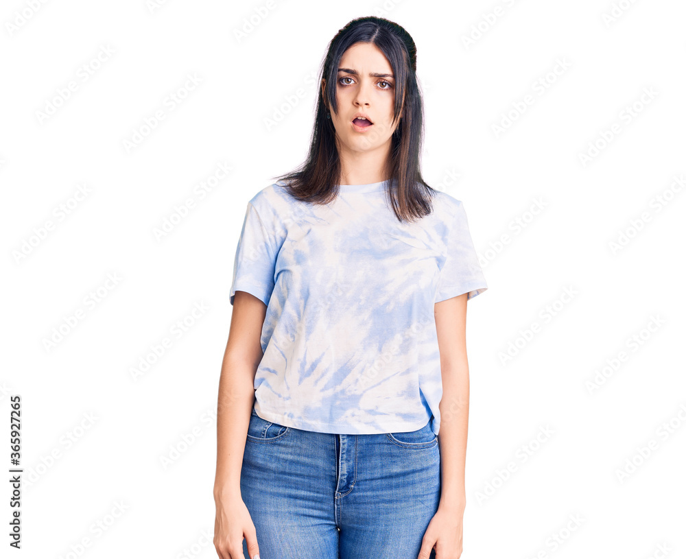 Young beautiful girl wearing casual t shirt in shock face, looking skeptical and sarcastic, surprised with open mouth Young beautiful girl wearing casual t shirt in shock face, looking skeptical and sarcastic, surprised with open mouth