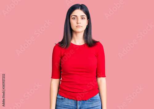 Young beautiful girl wearing casual t shirt with serious expression on face. simple and natural looking at the camera.