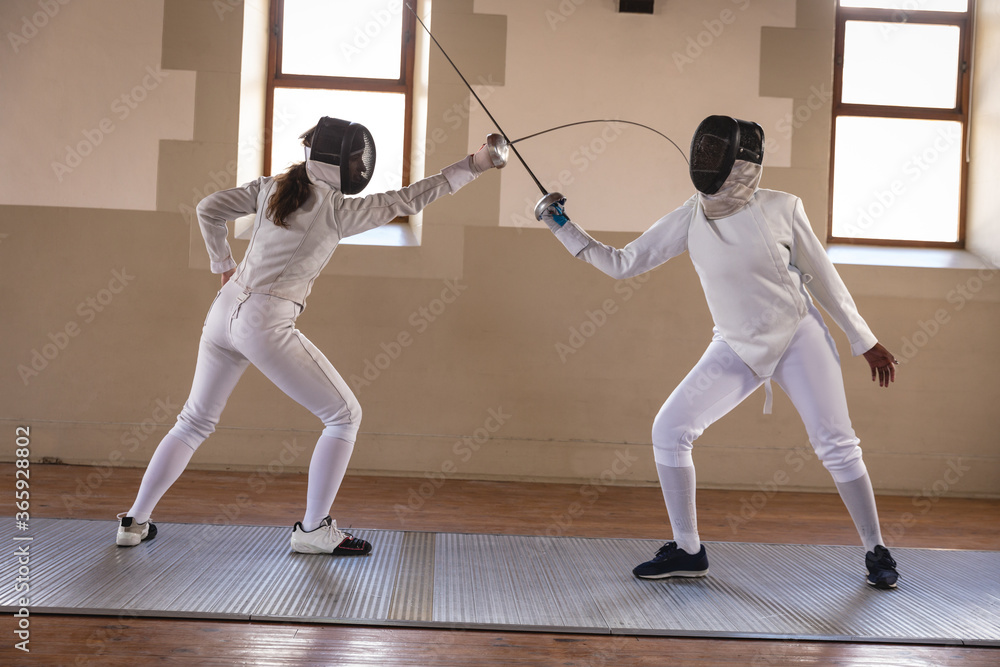 Two female fencers practicing fencing Two female fencers practicing fencing