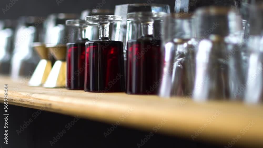 Clean Glasses Lined Upside Down On The Wooden Table In The Bar - selective focus trucking shot Clean Glasses Lined Upside Down On The Wooden Table In The Bar - selective focus trucking shot