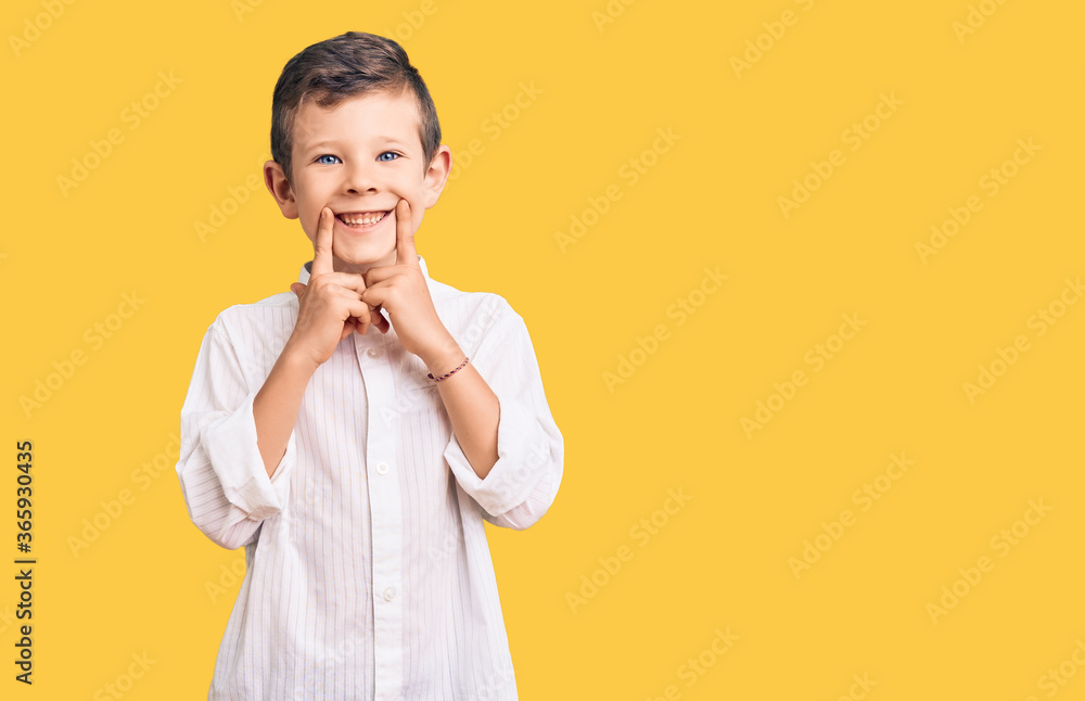 Cute blond kid wearing elegant shirt smiling with open mouth, fingers pointing and forcing cheerful smile Cute blond kid wearing elegant shirt smiling with open mouth, fingers pointing and forcing cheerful smile