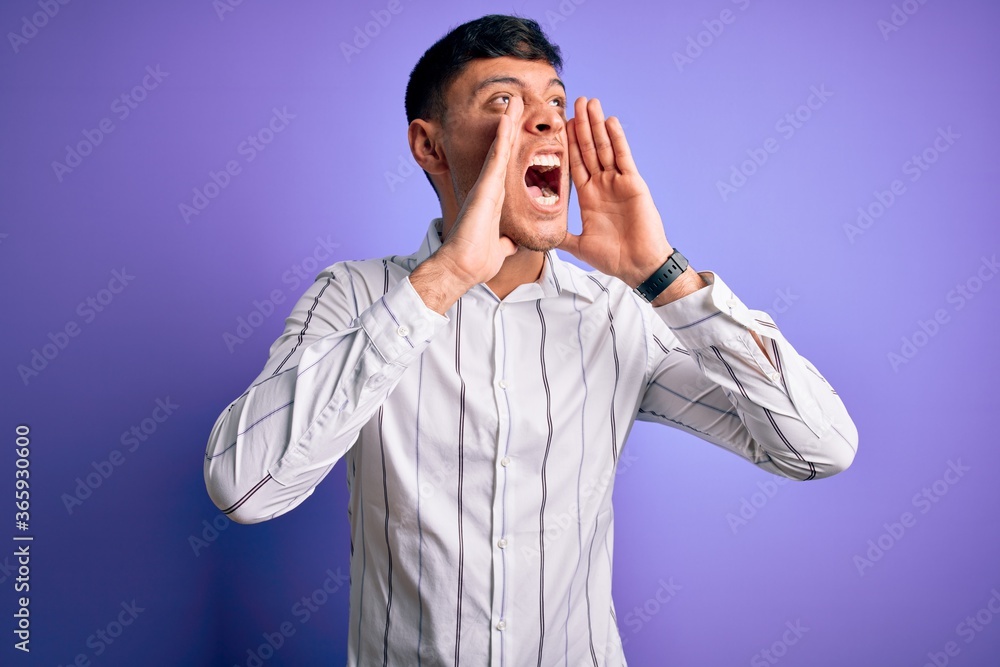 Young handsome hispanic man wearing elegant business shirt standing over purple background Shouting angry out loud with hands over mouth Young handsome hispanic man wearing elegant business shirt standing over purple background Shouting angry out loud with hands over mouth