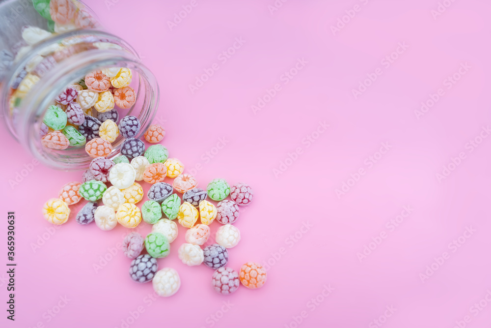 Colorful hard candies on pink background