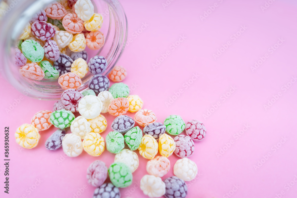 Colorful hard candies on pink background
