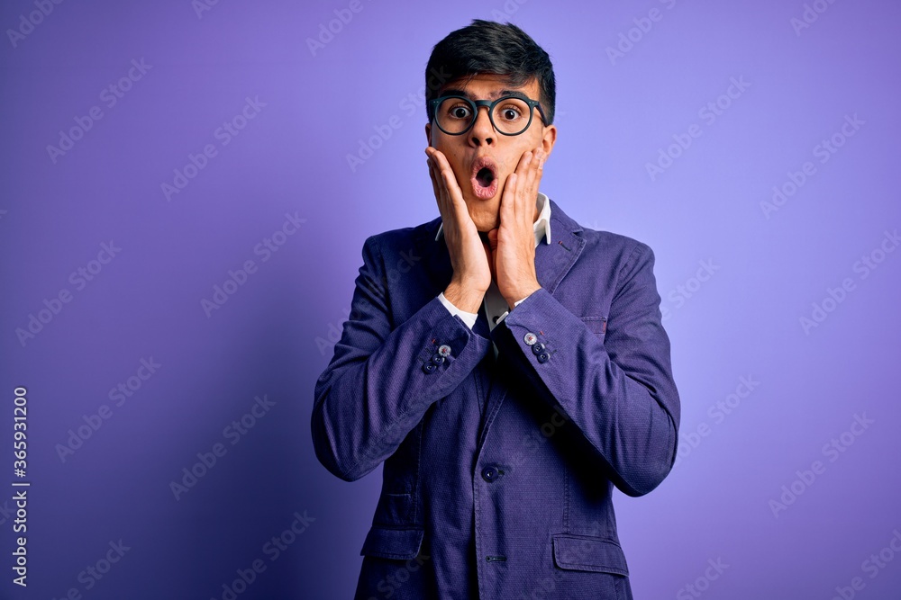 Young handsome business man wearing jacket and glasses over isolated purple background afraid and shocked, surprise and amazed expression with hands on face Young handsome business man wearing jacket and glasses over isolated purple background afraid and shocked, surprise and amazed expression with hands on face