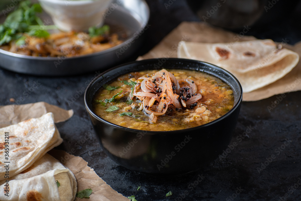 Vegan split yellow pea soup with caremelized onions, flat breads. Black background, copy space Vegan split yellow pea soup with caremelized onions, flat breads. Black background, copy space