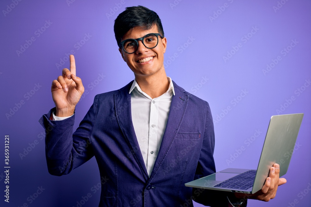 Young handsome business man wearing glasses working using laptop over purple background surprised with an idea or question pointing finger with happy face, number one Young handsome business man wearing glasses working using laptop over purple background surprised with an idea or question pointing finger with happy face, number one