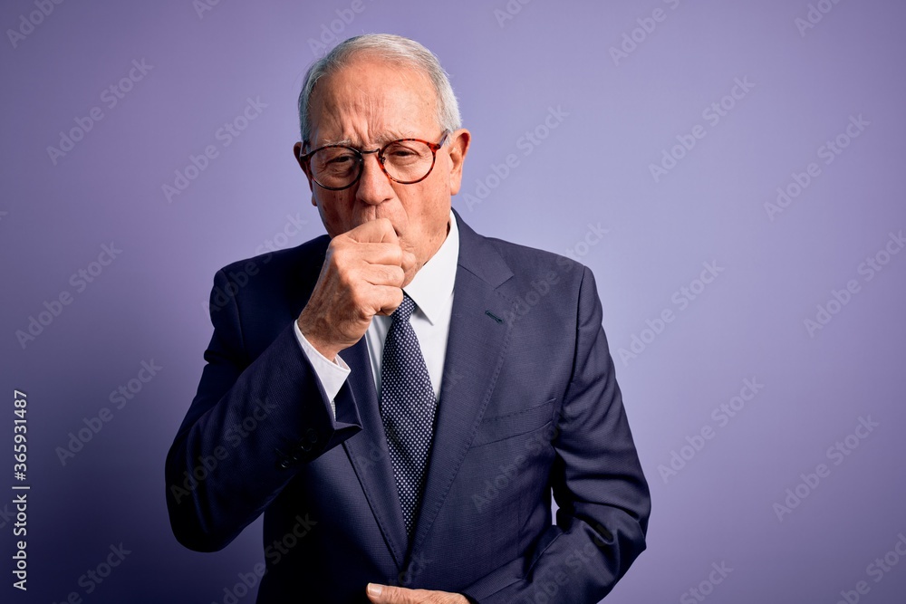 Grey haired senior business man wearing glasses and elegant suit and tie over purple background feeling unwell and coughing as symptom for cold or bronchitis. Health care concept. Grey haired senior business man wearing glasses and elegant suit and tie over purple background feeling unwell and coughing as symptom for cold or bronchitis. Health care concept.