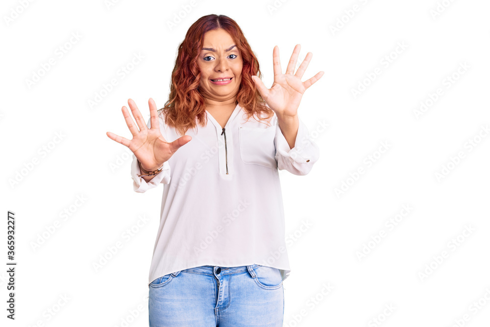 Young latin woman wearing casual clothes afraid and terrified with fear expression stop gesture with hands, shouting in shock. panic concept. Young latin woman wearing casual clothes afraid and terrified with fear expression stop gesture with hands, shouting in shock. panic concept.