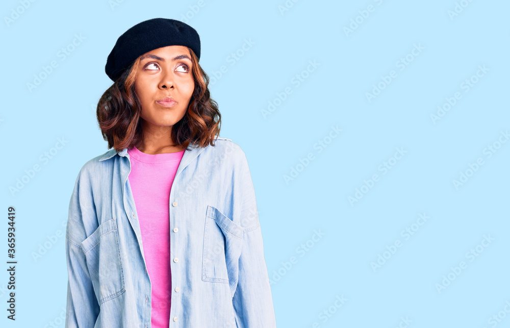 Young beautiful mixed race woman wearing french look with beret smiling looking to the side and staring away thinking. Young beautiful mixed race woman wearing french look with beret smiling looking to the side and staring away thinking.