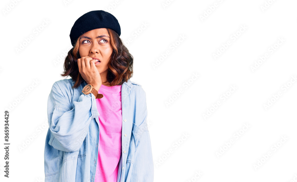 Young beautiful mixed race woman wearing french look with beret looking stressed and nervous with hands on mouth biting nails. anxiety problem. Young beautiful mixed race woman wearing french look with beret looking stressed and nervous with hands on mouth biting nails. anxiety problem.