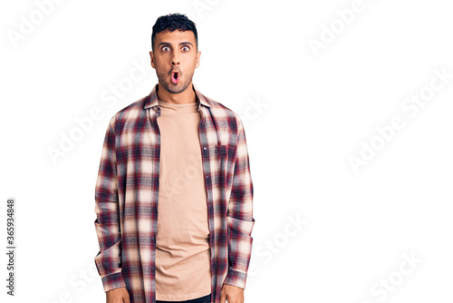 Young hispanic man wearing casual clothes scared and amazed with open mouth for surprise, disbelief face